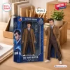 Front view of Doctor Who Heritage Collection Hot Toys figure beside its blue branded display box on a wooden desk.