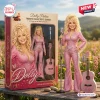 Front view of the Dolly Parton Tribute Collector's Edition Doll standing outside next to its packaging box and a miniature guitar.