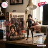 Hand holding a Dr. Frank-N-Furter 50th Anniversary Hot Toys figure beside its illustrated collector packaging box.
