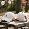 Side-by-side view of two cream baseball caps featuring coffee drink embroidery and sports logos.