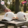 Close-up of two off-white Dunkin Donuts Chicago Bears baseball caps sitting on a wooden outdoor table.