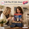 Two women holding the Famous Painting Cat 2027 Calendar while sitting on a couch.