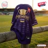 Back view of Fremantle Dockers AFL 2026 Champions Baseball Jersey draped over a wooden fence at a stadium.