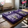 Two folded purple jerseys featuring Fremantle Dockers AFL 2026 Premiers graphics resting on a wooden bench.