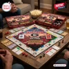 High-angle view of a Georgia Bulldogs Collector Edition Monopoly game set up on a wooden table with board and game boxes.