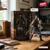 Action figure holding a sword standing next to its boxed packaging on a wooden desk.