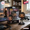 Front view of a Lucia Funko Pop figure next to its window box on a wooden desk with a gaming keyboard.