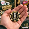 Hand holding a poker chip featuring a football trophy, laurel leaves, and the number 50 with green and black accents.