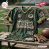 Front view of a green distressed football t-shirt featuring Packers branding and 1919 text on a wooden bench.