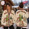 Front and back view of a woman wearing a cream holiday cardigan featuring a green character, tree, and dog motif.
