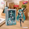 Front view of the Hatsune Miku 20th Anniversary Action Figure next to its packaging box on a wooden desk.