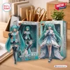 Two boxed action figures with turquoise twin-tail hair displayed on a wooden desk.