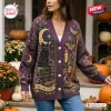 Front view of a purple knitted cardigan featuring a black cat, crescent moon, and spell book design.