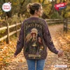 Back view of a person wearing a purple Hocus Pocus Sanderson Sisters knitted cardigan in a park during autumn.