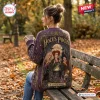 Rear view of a person wearing a purple Hocus Pocus Sanderson Sisters knitted cardigan while sitting on a park bench.