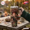 Hand holding a 40oz Stanley tumbler featuring Winifred Sanderson graphics and I Put A Spell On You text, outdoors.