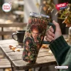 Hand holding a 40oz Stanley Tumbler featuring a Winifred Sanderson character graphic and text on a rustic outdoor table.