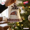 Close view of a white bell ornament with a motorcycle topper, brand logo, and 125th anniversary text on a tree.
