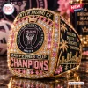 Closeup of a gold championship ring with pink accents and Inter Miami CF team lettering.