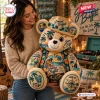 A woman holding a Jimmy Buffett plush teddy bear wearing a tropical straw hat and printed shirt in a room.