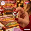 Close-up of a hand holding a metallic arrowhead game token featuring the Kansas City Chiefs Monopoly Board Game logo.