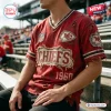 Close-up of a person wearing a red distressed Kansas City Chiefs football t-shirt with frayed edges and team patches.
