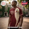 Kappa Alpha Psi Achievement Heritage T-Shirt in maroon and cream with fraternity crest and scripted text on a man.