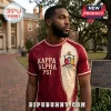 Kappa Alpha Psi Achievement Heritage T-Shirt in crimson and cream with fraternity crest and Greek letters on a man.