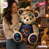 Woman holding a tan plush bear wearing a straw cowboy hat with palm tree and text graphics throughout.