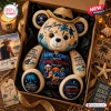 Front view of a Kenny Chesney Collector Plush Bear wearing a straw cowboy hat in a gift box with beach theme graphics.