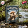 Front view of the Lovely Otter Advent Calendar box sitting on a mossy log next to a flowing river.