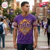 Front view of a man wearing a purple LSU Tigers t-shirt featuring a mascot graphic on a college campus background.
