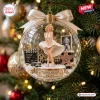 Front view of a clear globe Christmas ornament containing a blonde figure, film clapperboard, and a star emblem.