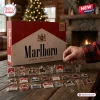 Marlboro Advent Calendar 2026 box with 24 acrylic collectible ornaments displayed on a wooden table in a festive room.