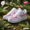 Pair of custom Mickey Mouse Breast Cancer Awareness Air Force 1 sneakers placed outdoors on mossy ground.