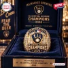 Closeup of a gold Milwaukee Brewers 2026 Champions championship ring resting in a dark blue display case.