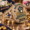 Side angle of a gold championship ring with blue accents, featuring baseball team text and a skyline design element.