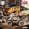 Front view of a plush mascot pillow holding a 2026 NL Central Champions pennant and baseball while sitting on a table.