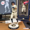 Front view of a baseball player figurine on a round Milwaukee Brewers base next to its packaging box.