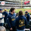 People in the stands at a baseball stadium wearing navy blue Milwaukee Brewers October Baseball 2026 hoodies.