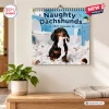 Front view of Naughty Dachshunds 2027 Wall Calendar hanging on a wall above a wooden table.