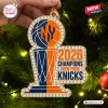 Close-up of a New York Knicks 2026 NBA Champions acrylic ornament featuring basketball and trophy motifs against a tree.