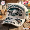 Close-up of a distressed off-white Philadelphia Eagles baseball cap on a wooden table.