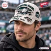 Front view of a man wearing an NFL Philadelphia Eagles distressed baseball cap with stadium background.