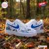 Side view of Nightmare Before Christmas Blue Awareness Air Force 1 Sneakers resting on autumn leaves.