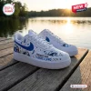 Pair of Nightmare Before Christmas Blue Awareness Air Force 1 Sneakers resting on a wooden dock outdoors.