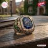 Close-up view of a Notre Dame Fighting Irish 139th Anniversary ring featuring a large blue stone on a wooden table.