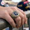 Closeup of a gold tone Notre Dame Fighting Irish 139th Anniversary Ring worn on a finger.
