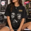 Front view of a person wearing a black t-shirt featuring a band name logo and a portrait of two men in sunglasses.