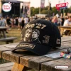 Side view of a black baseball cap featuring embroidered text live '27 and a duo of portraits on a wooden bench.